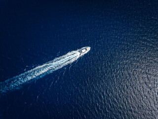 Wall Mural - high aerial view of a luxury yacht traveling over the sparkling ocean