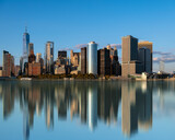 Fototapeta  - Lower manhattan  cityscape, Panoramic landscape with water reflection obut New York city USA. Clear blue sky and amazing mirrored skyscrapers.