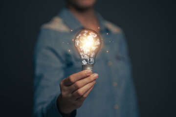 Poster - A businessman is holding a light bulb. The concept of finding ideas for business, ideas for education, ideas for finding new ways to live life.