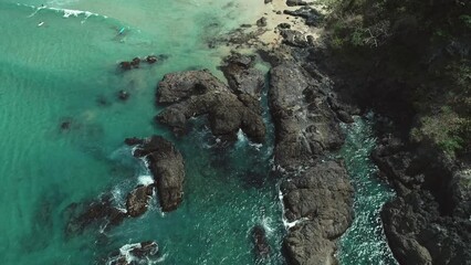 Poster - Aerial top view of sea waves crushing into the rocks near beach. Drone shot of sea waves on the dangerous stones.