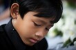 © Rudsaphon - Portrait of little asian boy with sad expression.Funeral concept