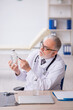 © Elnur - Old male doctor working in the clinic