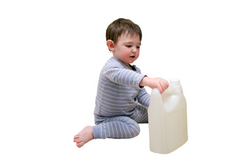 A child is playing with chemical cleaning products under the sink in the kitchen, isolated on white background. Baby holds bottles with detergent. Kid aged about two years (one year nine months)