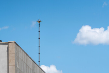 Lightning rod on the roof of a building against a blue sky. Lightning strike