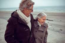 Senior Caucasian Couple Bonding And Having A Stroll On The Beach At Winter