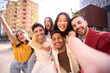 © CarlosBarquero - Big group of friends in piggyback taking selfie smiling at camera. Young people celebrating outside and having fun. Portrait of millennial guys and girls enjoying vacation. Multiracial best friends
