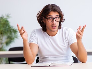 Wall Mural - Young male student sitting in the classroom