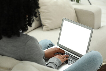 Poster - Woman using laptop on sofa indoors, closeup