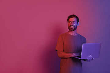 Canvas Print - Handsome man with laptop in neon lights, space for text