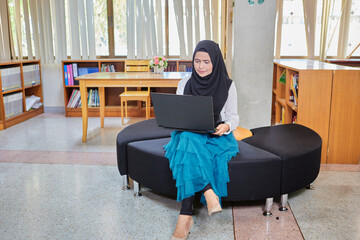 Wall Mural - Asian muslim woman in hijab using laptop in office