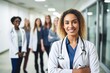 © Larisa - Young girl doctor in white coat and with stethoscope stands in the Hospital.