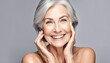 Adult woman with smooth healthy face skin. Beautiful aging mature woman with gray hair and happy smiling touch face