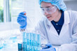 © Supapich - Professional scientist chemist technician analysis research experiment virus blue liquid pipette glass test tube equipment in hospital laboratory, woman doctor white lab coat medical research develop