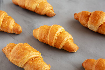Wall Mural - Homemade Croissants on a gray background, side view.