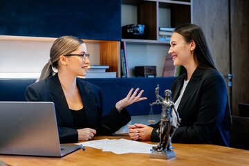 A female lawyer at her workplace communicates with a young client, discussing issues of legal significance. Consultation concept with legal and financial issues