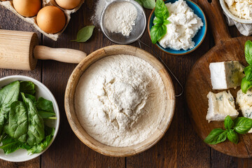Poster - Set of raw ingredients for cooking Italian ravioli with various cheeses and spinach on a wooden table top view