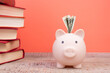 Piggy bank in glasses and books on Orange background. open book. Tuition payment. Brainwork. Back to School.