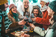 © Davide Angelini - Happy friends group toasting red wine dining at restaurant terrace - Young people socializing drinking and eating food sitting outside at winery bar table - Winter season - Dinner lifestyle concept