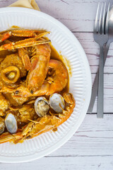 Wall Mural - Catalan authentic spicy Suquet de Peix soup with potatoes, shrimps, mussels, herbs and fish with picad close-up in a pan on the table. horizontal top view from above