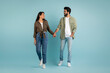 © Prostock-studio - Joyful beautiful eastern couple walking over blue background
