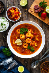 Wall Mural - Louisiana soup gumbo with shrimp, chorizo and white rice on wooden table 