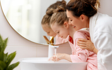 Wall Mural - girl and her mother are washing hands