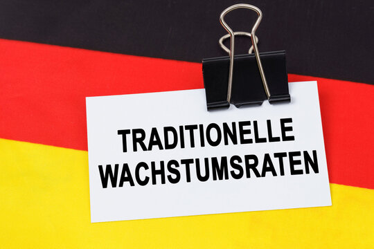 On the flag of Germany lies a business card with the inscription - traditional growth rates