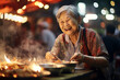 © toonsteb - Local female chef happily cooks at street food market