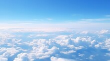 Panoramic View Of Fields And Clouds From An Airplane Window. The Sky Is A Bright Blue With Fluffy White Clouds.