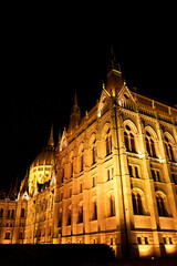 Wall Mural - Evening photo of the Parliament building in Budapest. The majestic Saxon architecture is illuminated with warm yellow light