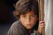 Emotional closeup of a refugee boy, lost in thought and longing for his home and family.