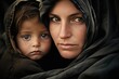 The closeup of a mother and child, both with tears in their eyes as they take shelter in a crowded refugee camp.