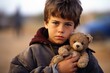 © Justlight - Closeup of a young boy holding a small teddy bear, a cherished possession that has traveled with him through the chaos and uncertainty of being a refugee.