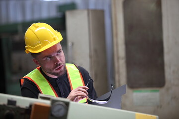 Wall Mural - worker or engineer working in factory with safety uniform , safety hat and safety glasses , image is safety concept or happy workplace