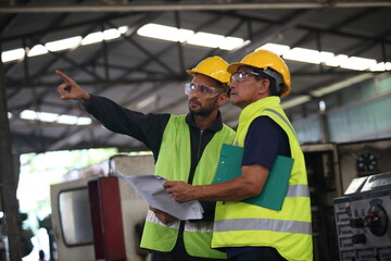 Wall Mural - worker or engineer working in factory with safety uniform , safety hat and safety glasses , image is safety concept or happy workplace