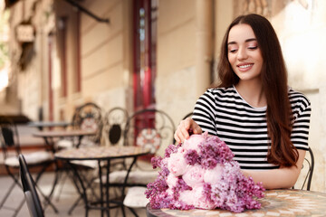 Wall Mural - Beautiful woman with bouquet of spring flowers in outdoor cafe, space for text