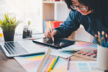 Fototapete - Graphic designer architects who work with laptops and color comparison tables for design work..