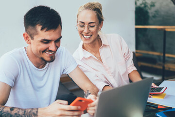 Cheerful male and female colleagues collaborating in cafe terrace