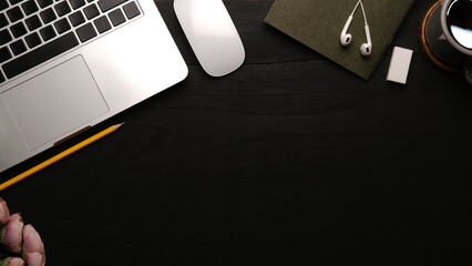 Wall Mural - Top view of  laptop, coffee cup, mouse and earphones on black table. Copy space for your text.