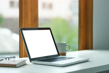 Wall Mural - laptop computer with blank display, cup of coffee and notebook on office desk.