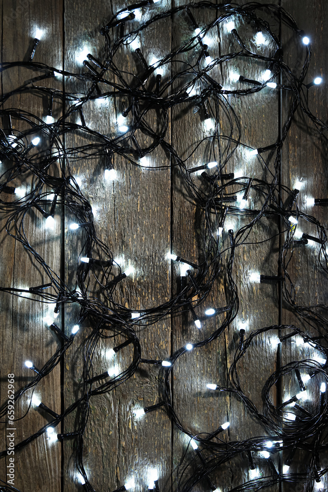 Christmas lights on dark wooden background