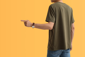 Sticker - Man in stylish t-shirt pointing at something on orange background