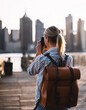 © BullRun - female tourist with trendy rucksack testing modern technology for making view photos