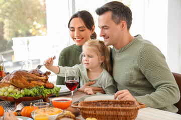 Poster - Little girl with her parents having dinner at festive table on Thanksgiving Day