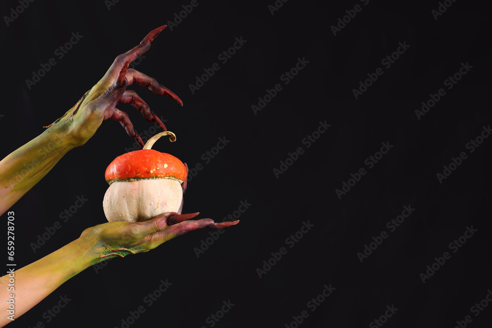 Witch with pumpkin on black background. Halloween celebration