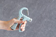 Woman's hand with hand expander. Adjustable heavy hand grip strengthening tool.