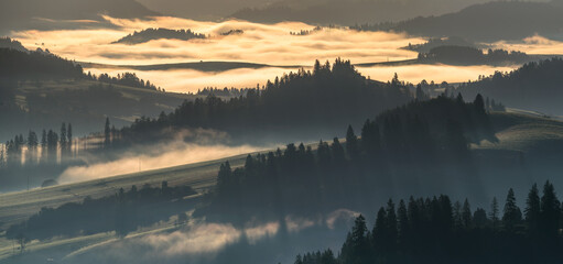 Wall Mural - beautiful sunrise in the picturesque mountains. picturesque mists rolling in the valleys illuminated