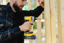 Blue-collar Worker Drilling Wood At Construction Site