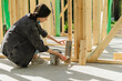© Westend61 - Blue-collar worker painting plank with paintbrush at construction site