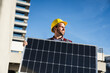 © Westend61 - Smiling engineer wearing hardhat holding solar panel on sunny day